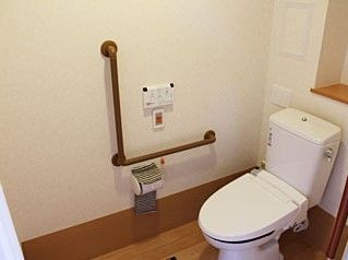L字型の手すりが付いているトイレの様子。緊急コールも取り付けてある