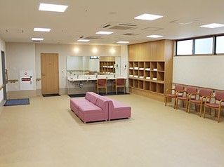 共有スペースに椅子やソファが並んでいる様子。下駄箱のようなものが見えている