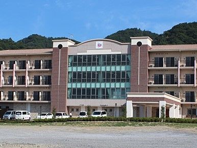 横に長い建物の外観と周りの景色、建物の前にある駐車場の様子