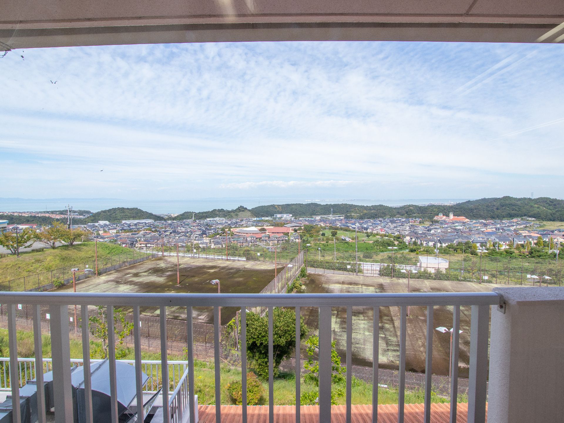 遠くに市街地が見え、手前に更地が見える、ベランダからの風景