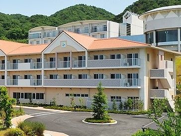 山に囲まれた環境の中にたたずむ施設の様子。広めの駐車場があるのが分かる