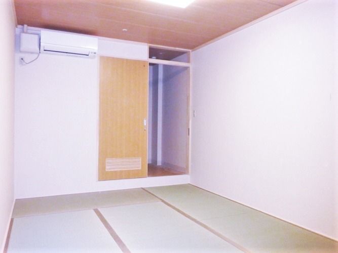 畳敷きの部屋にはエアコンが付き、引き戸を開けると廊下に続いている。家具などは置かれていない。