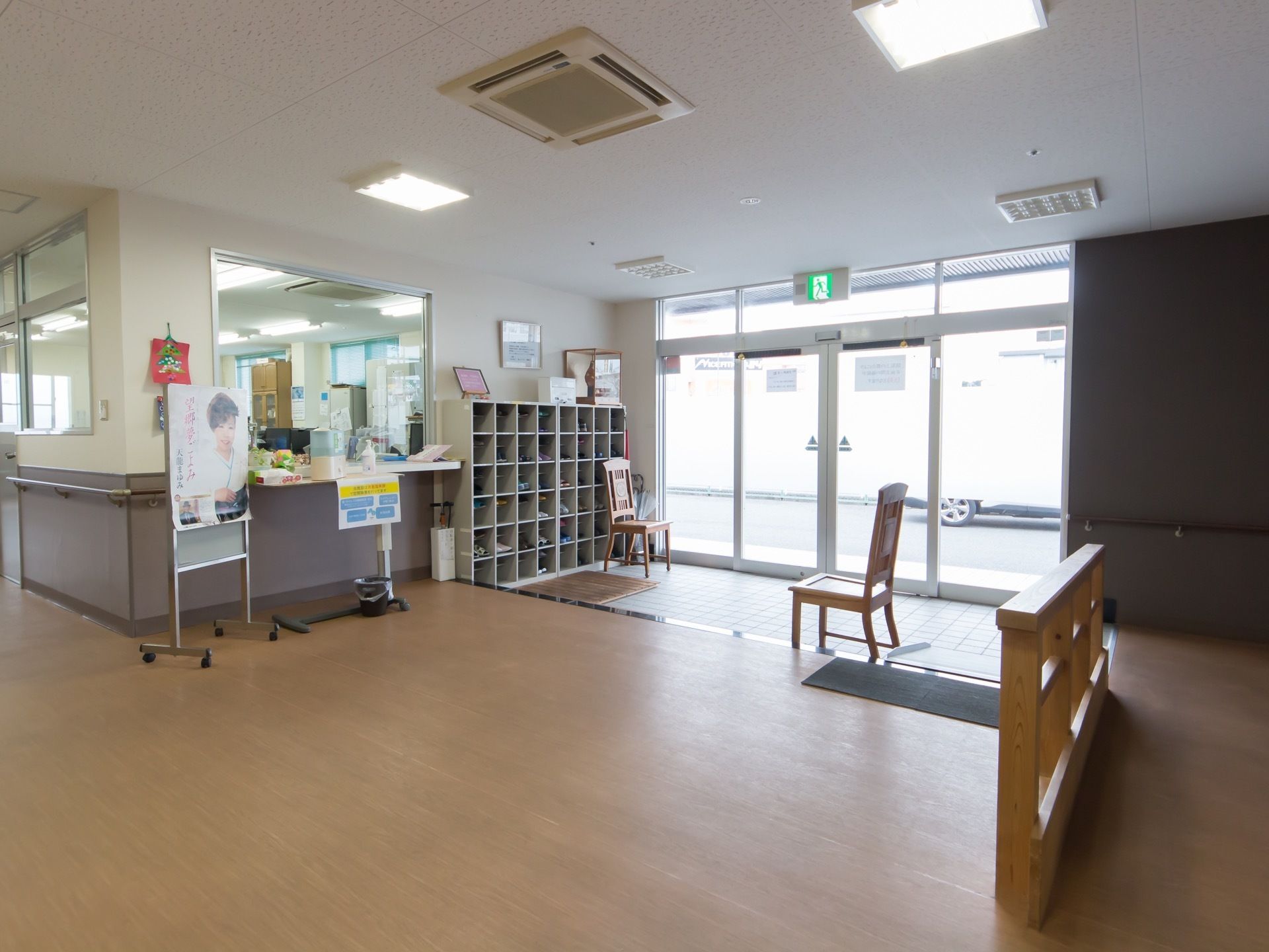 右側に自動ドアの設置された玄関がある。右側に受付窓口があり、その奥に事務室になっている。玄関の三和土には、椅子が２脚置かれている。