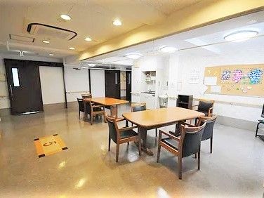 洗面所やキッチンも完備された共有スペースにはダイニングテーブルが複数並び、入居者の作品が壁に飾られている。
