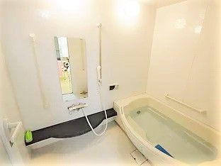 一般の住宅と変わらない造りの浴室。浴槽の横にはたくさんの手すりが設置されている。
