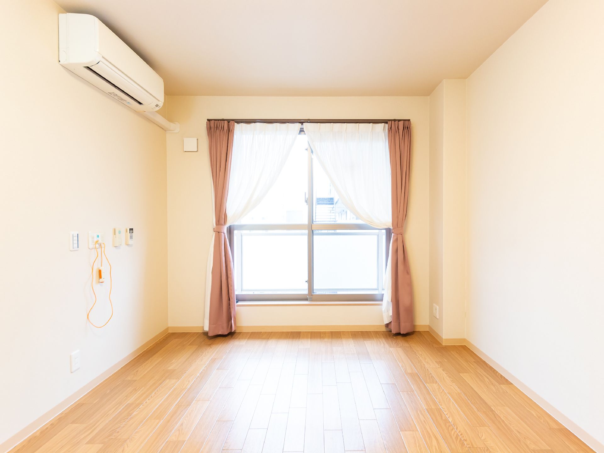 エアコンとベージュ色のカーテンがあるシンプルなお部屋