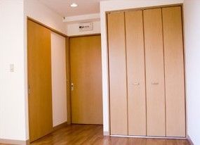 フローリングの居室には大きな収納が付き、白い壁によく映える木目調となっている。