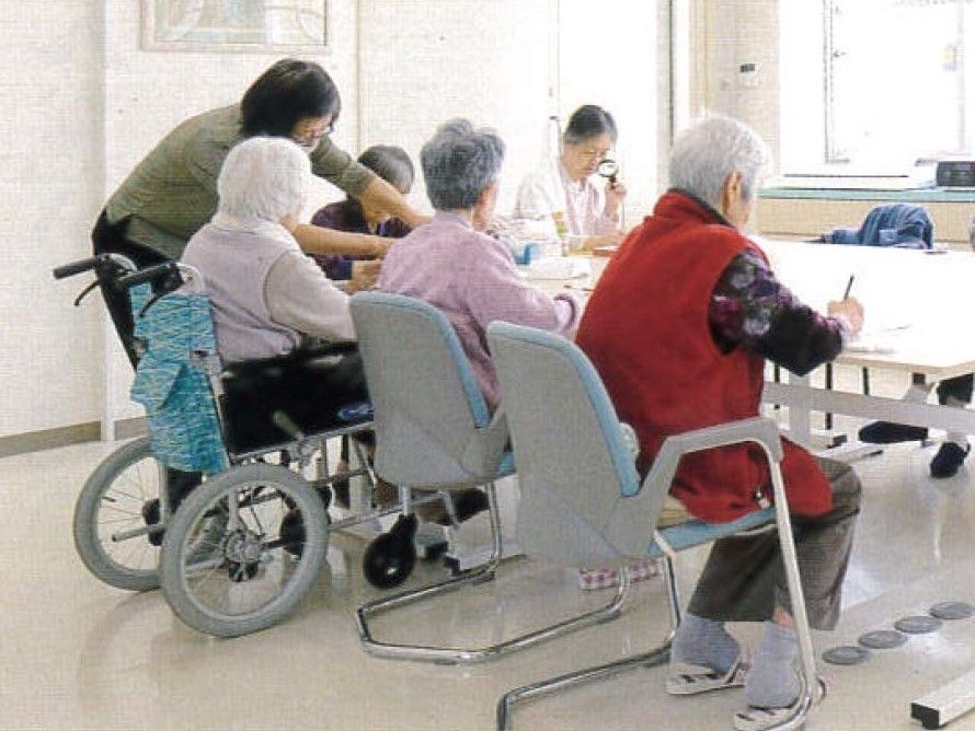 食堂では入居者が集まり、テーブルでレクリエーションをしている風景。