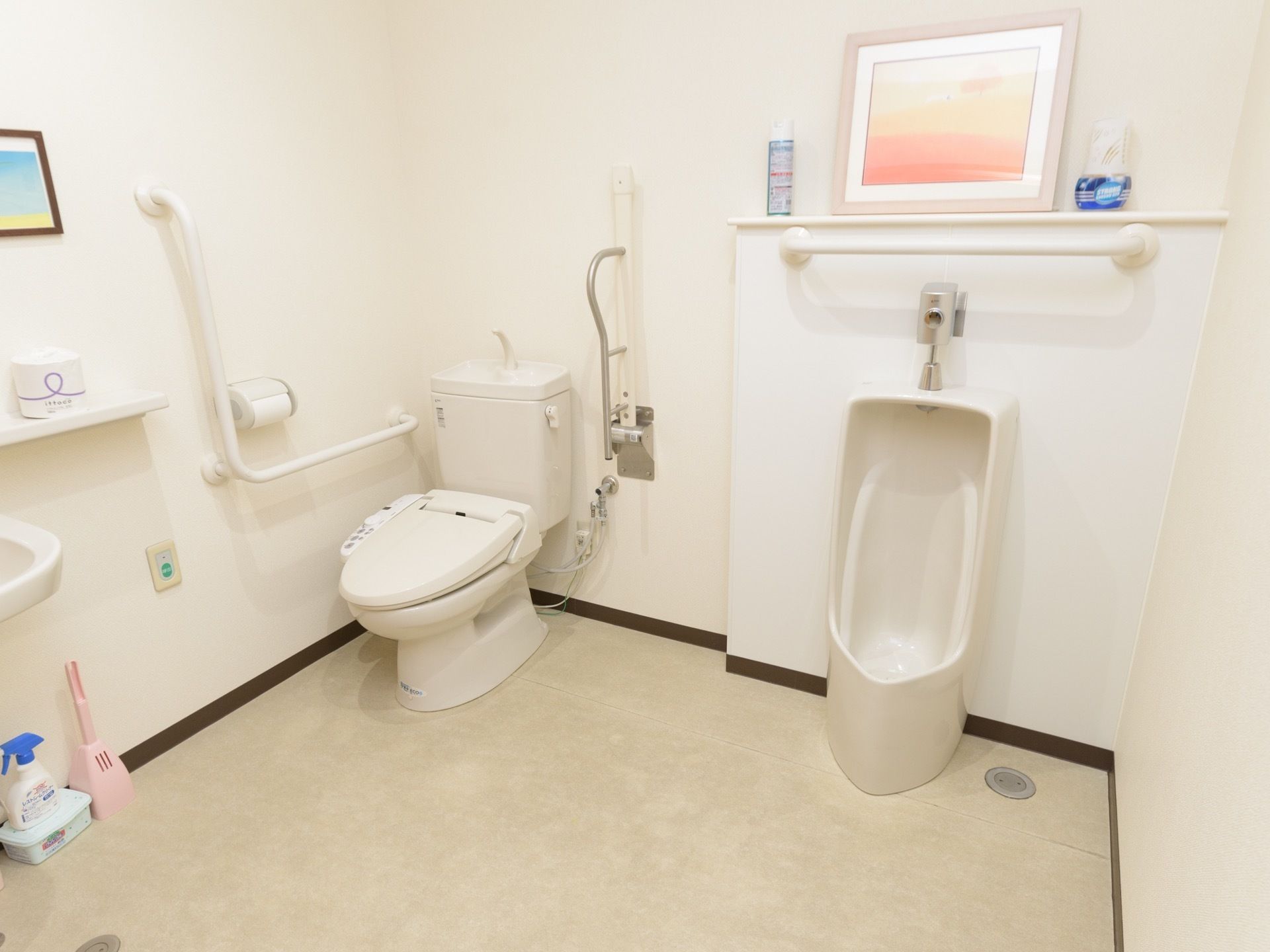 ゆったりとしたスペースを確保し、壁に手すりが取り付けられたトイレには、温水洗浄便座器と男性用小便器を並べて設置している。