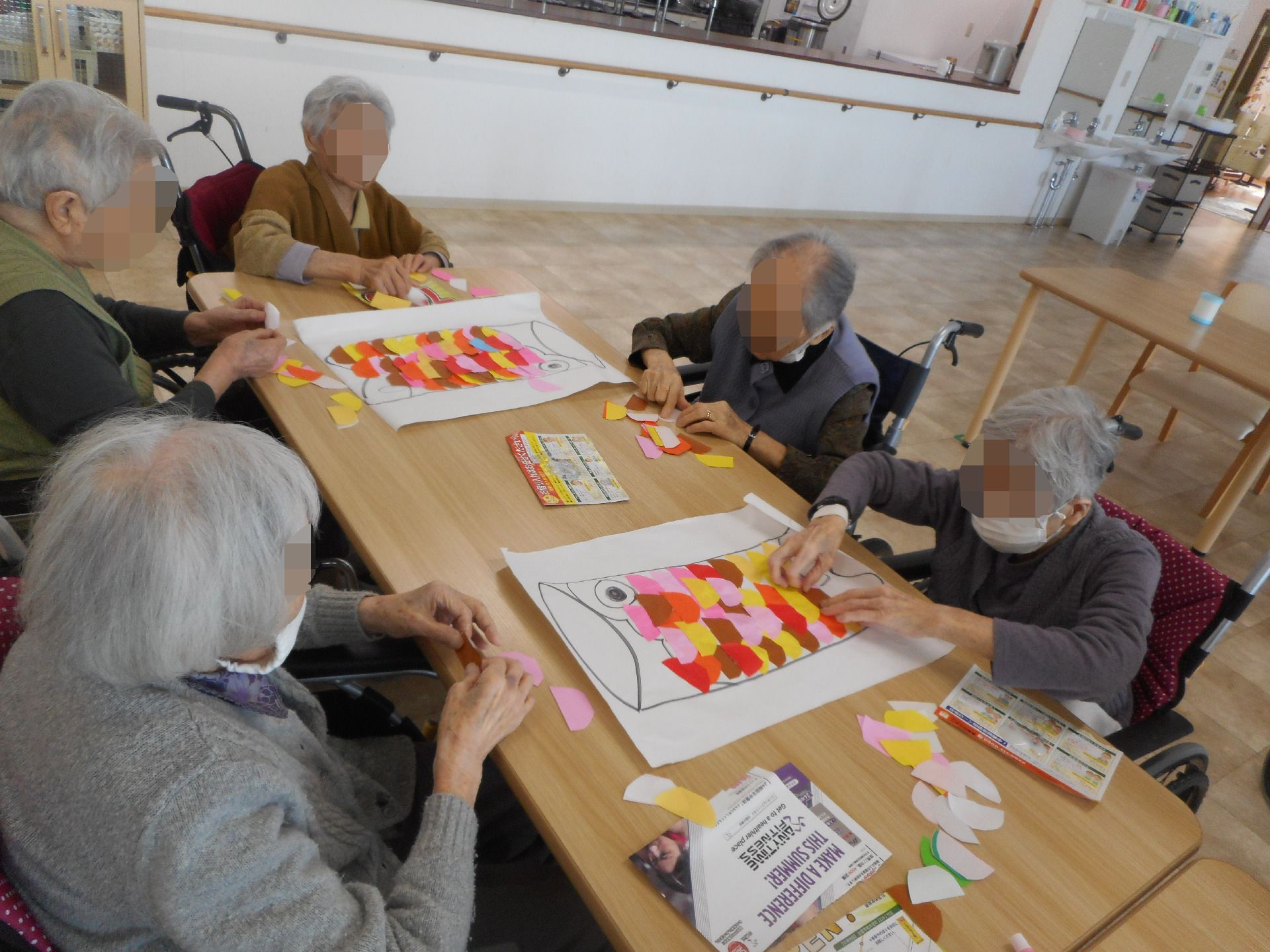 カラフルなこいのぼりを作って遊ぶ高齢者たち