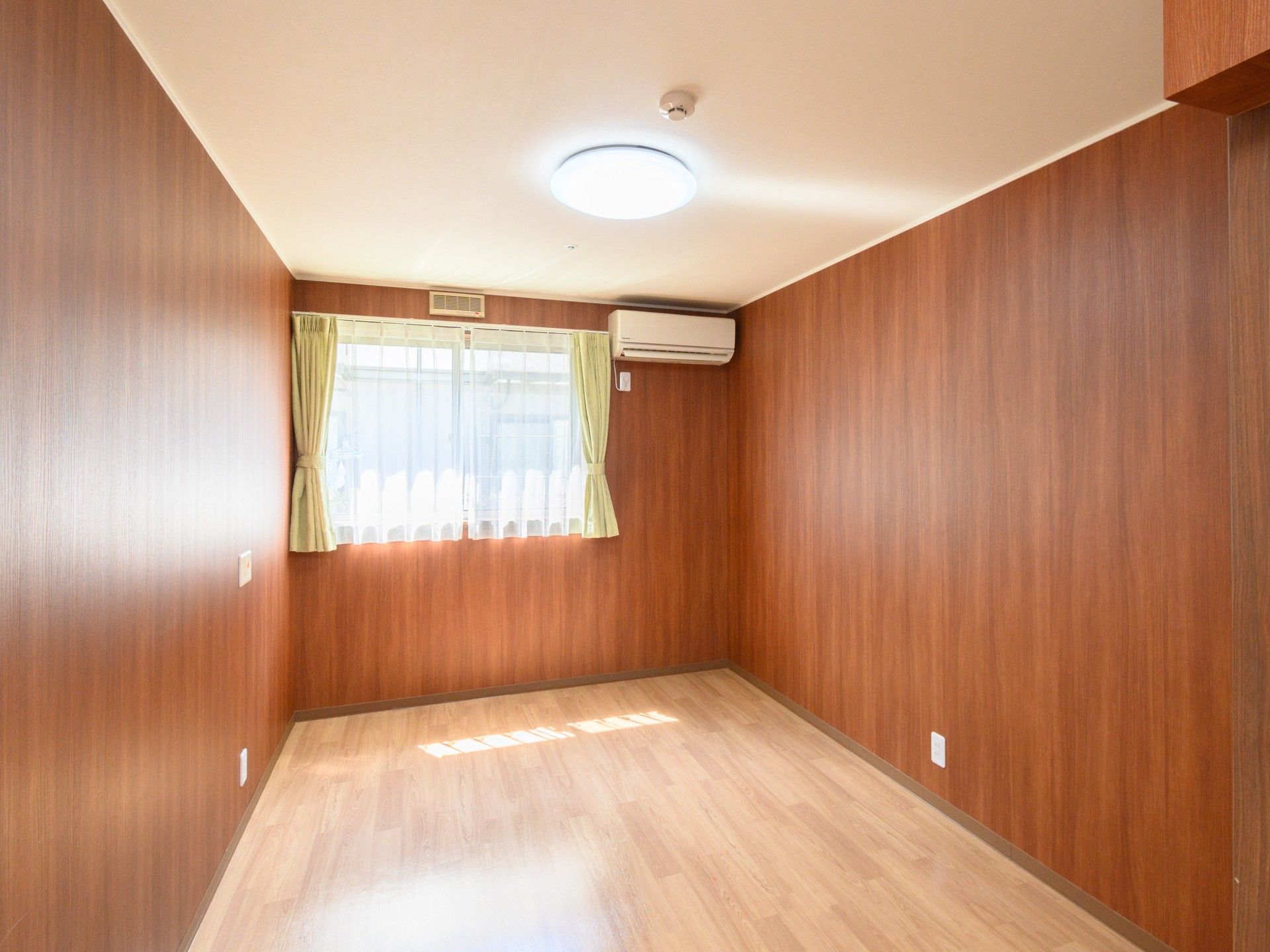 自宅に近い雰囲気の居室。家具や家電もそろい、木のぬくもりが感じられる部屋。