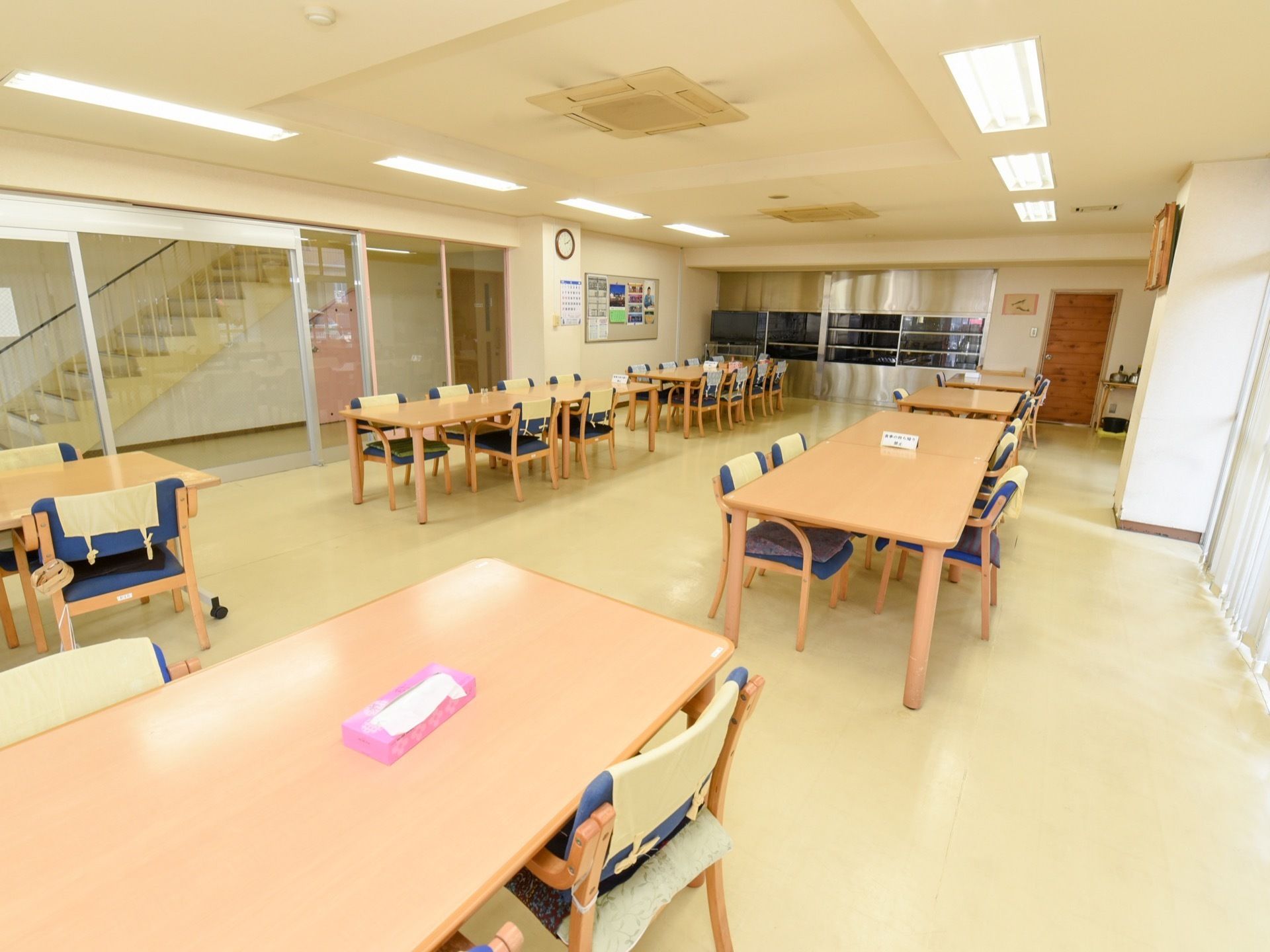 食堂と通路の間の壁はガラス張りのため、圧迫感がなく広さを感じることができる。ダイニングセットはスペースに余裕をもって配置されている。