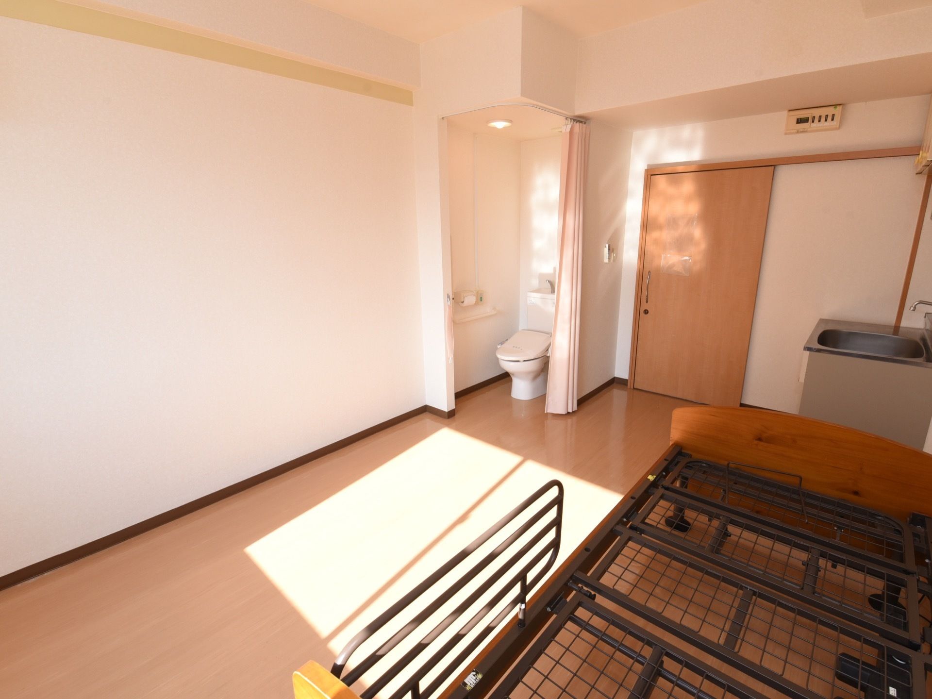 居室にはベッド枠とシンク、トイレがついている。トイレの仕切りはカーテンである。ドアはスライド式を採用している。