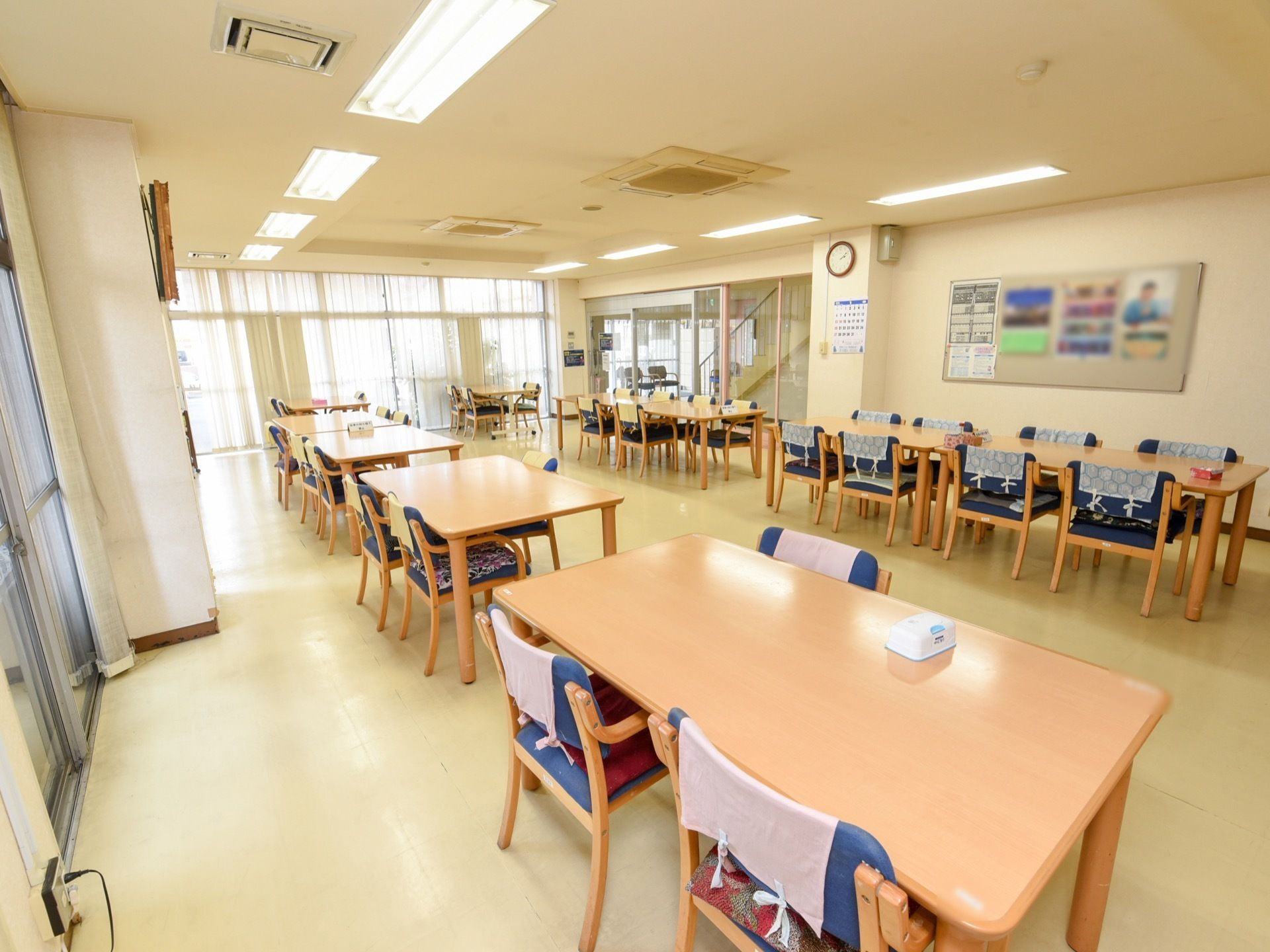 フロアに４人がけテーブルが２列に並んでいる。テーブル2つを合わせて８名で席を囲めるようにセットしてある。