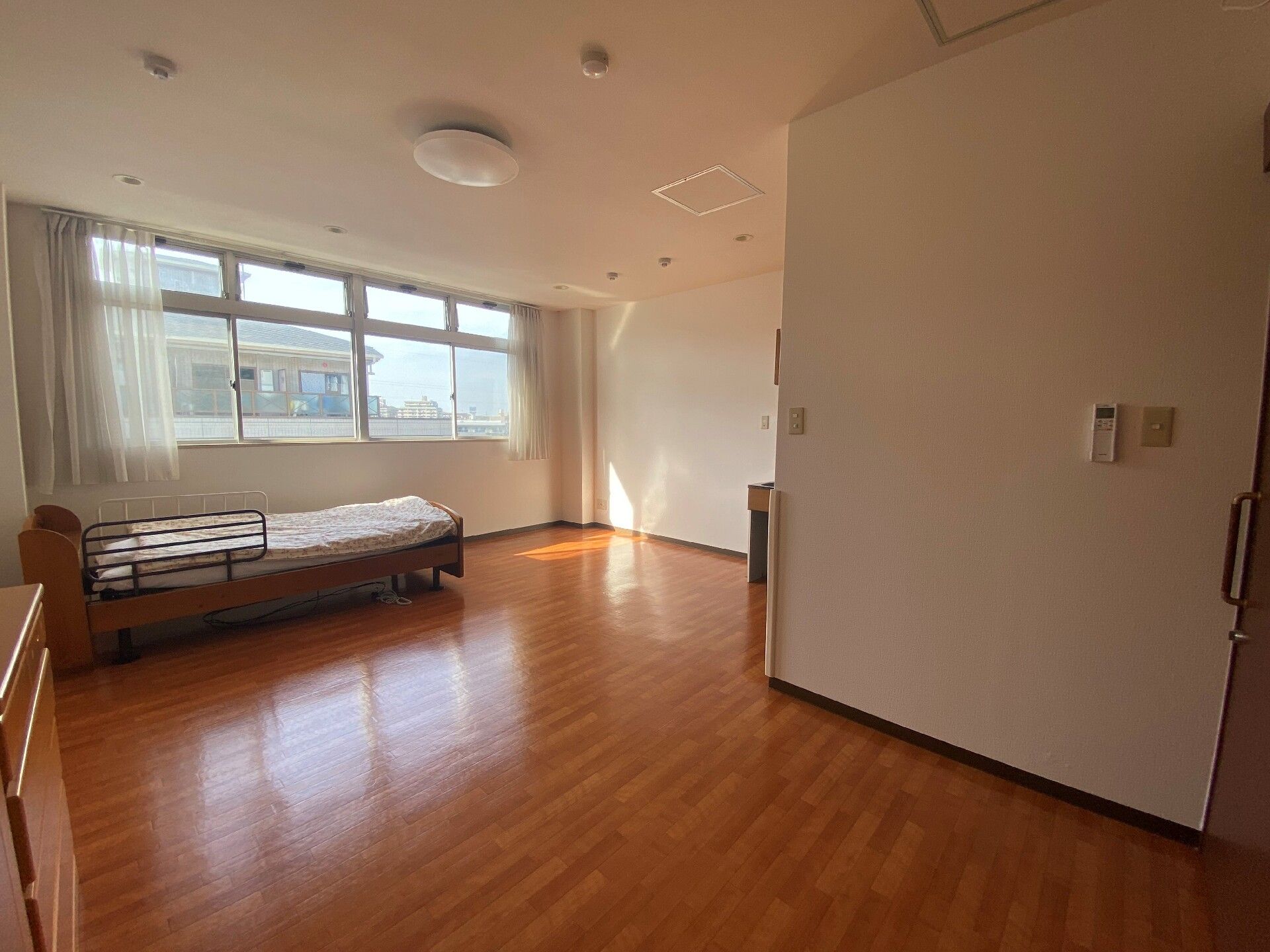 お部屋は介護ベッド・エアコン・カーテン付き。