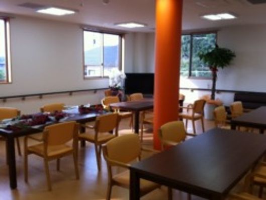 中央にはオレンジの大きな柱があり、ダイニングテーブルが複数並んでいる。