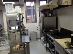 ステンレス製のキッチンはきれいに掃除がされている。本格的な器具がそろい、収納スペースもある。
