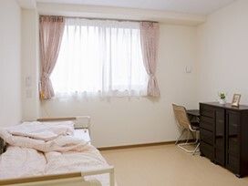 右にタンス、左にベッドが置いてある施設内の居室。飾り付けられている様子