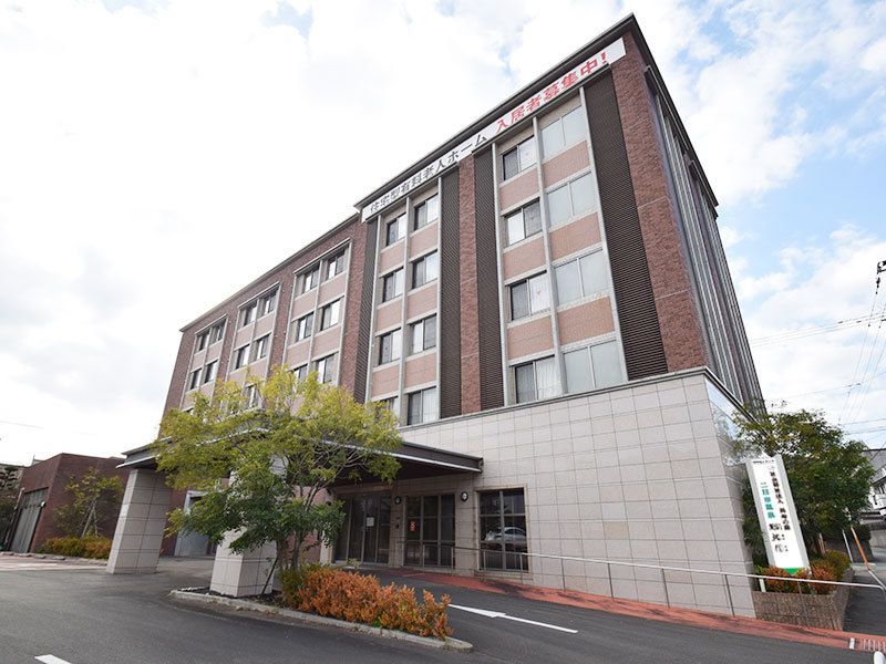 ５階建ての建物はホテルのよう。車寄せも幅が広く、季節の花や木も植えられている。