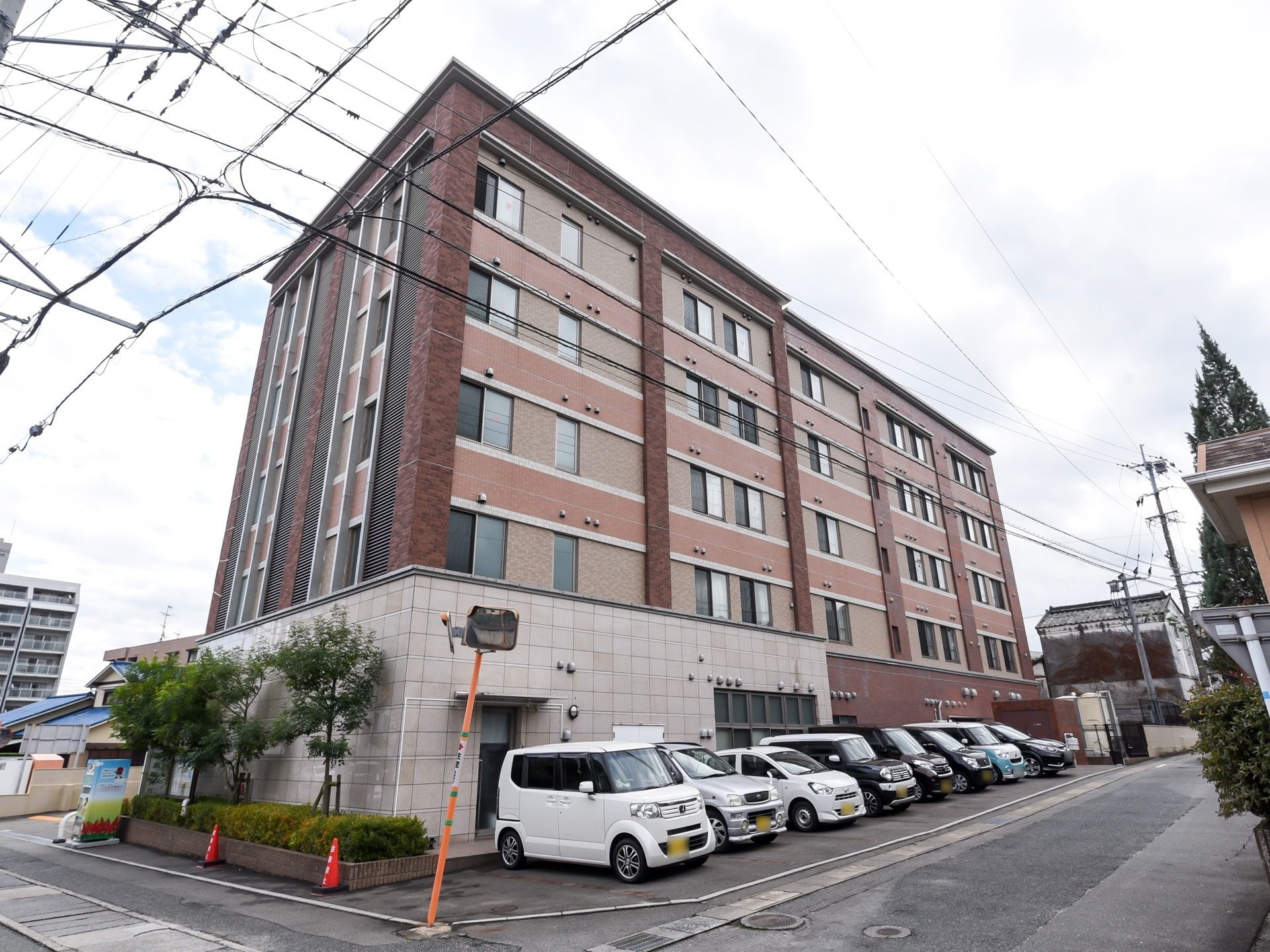 親しみやすい、落ち着いた外観の施設である。建物の目の前には、駐車場がある。複数台の車が駐車している。