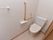 トイレの壁には、手すりがL字型に設置されている。立ち座りの際に体を支えることができるので安心である。