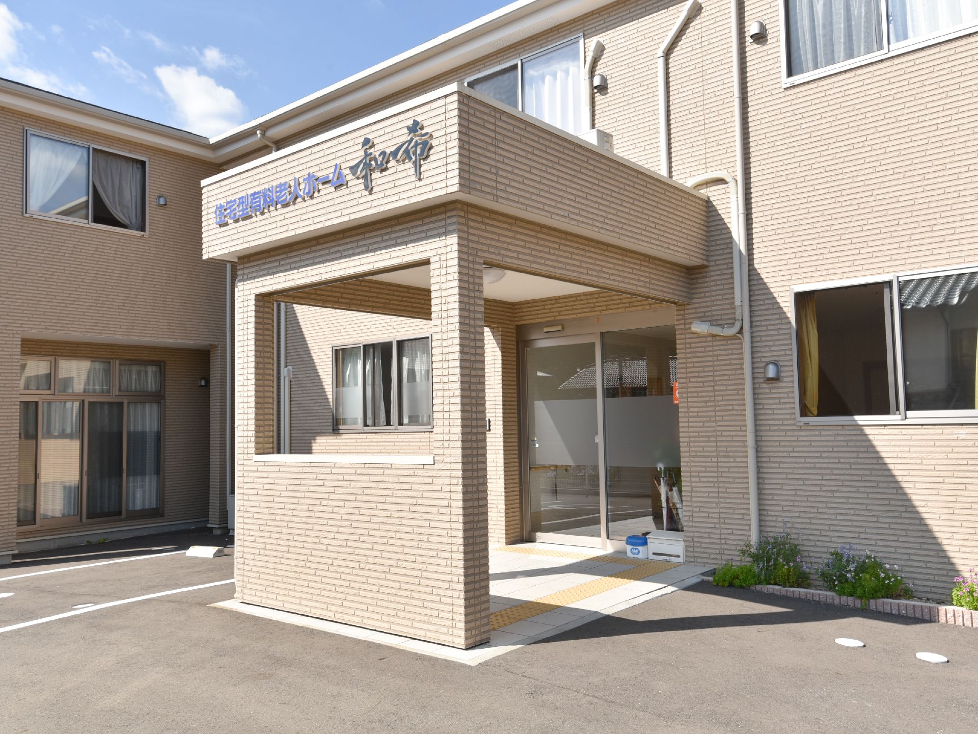 正面からホームを見た様子。2階建ての建物はブラウン調でまとめられていて、落ち着いた雰囲気。