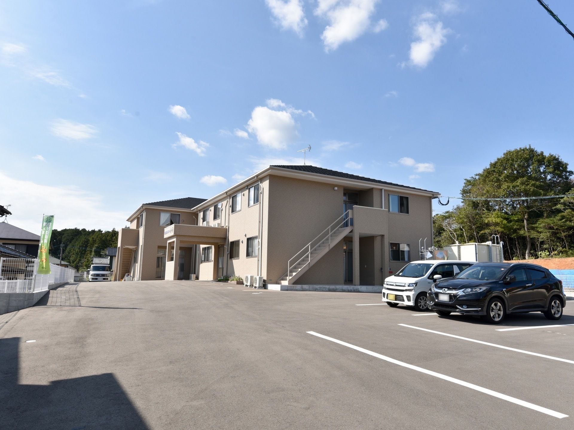ブラウン系の2階建てのホームを斜め横から眺めた様子。建物周辺には余計なものが置かれておらずすっきりしている。
