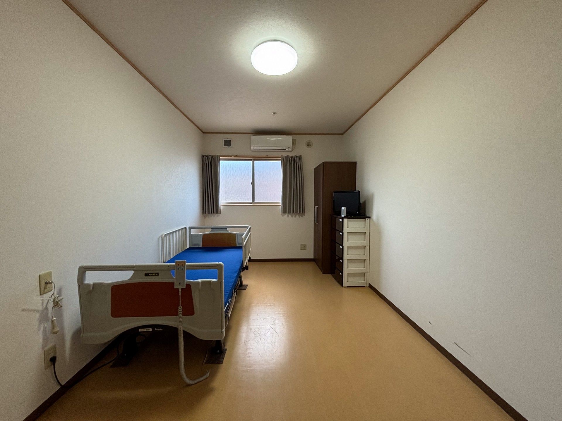 カルテのようなものを見ながら話しているエプロンを付けた若い女性スタッフ。高齢女性が真剣な表情で聞いている。