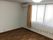 レースカーテンとカーテンが付いた大きな窓があるフローリングの部屋にはエアコンもある。