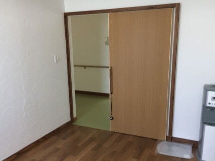 ワイドタイプのスライド式のドアが設置されている。ドアの手すりにはひものようなものが付いている。