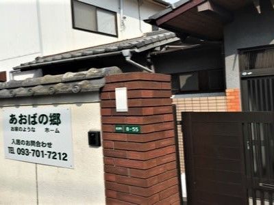 外壁にはホームの看板が設置され、門を入ると一般家庭のような和風の建物が建っている。