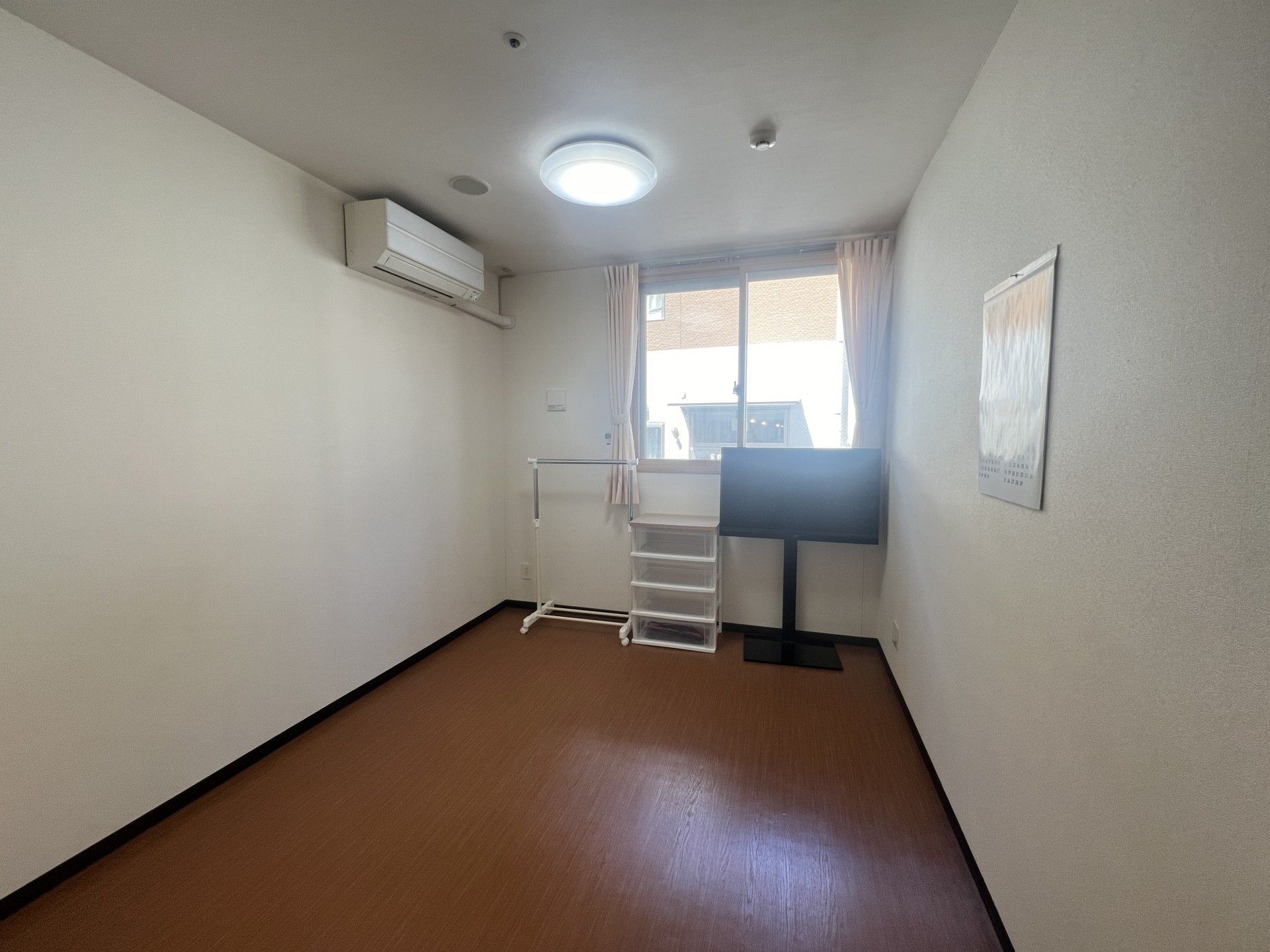 大型テレビと収納家具、エアコンがある部屋