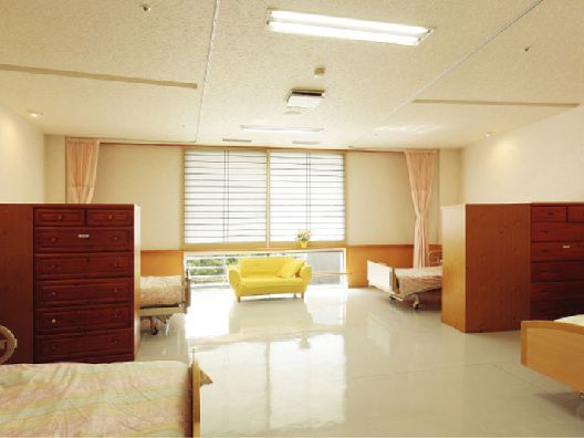 ソファが置かれた部屋には介護ベッドが4台あり、それぞれのスペースを家具やカーテンで仕切ることができる。