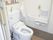 緊急コールと手すりが取り付けられている引き戸仕様の介護用トイレの様子