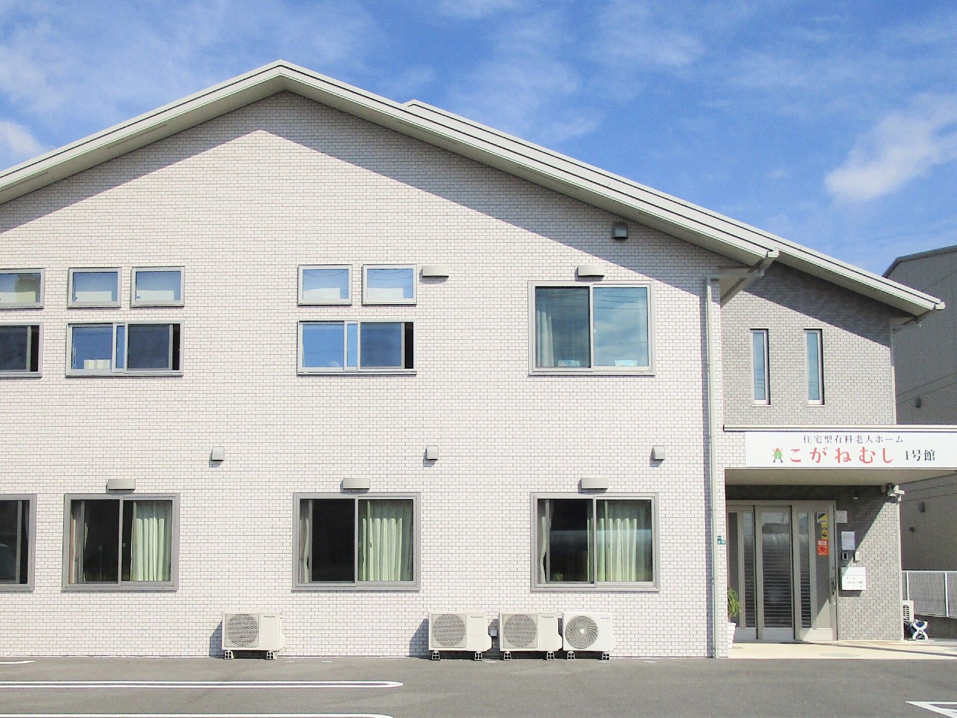 玄関前に屋根が設けられた2階建ての建物