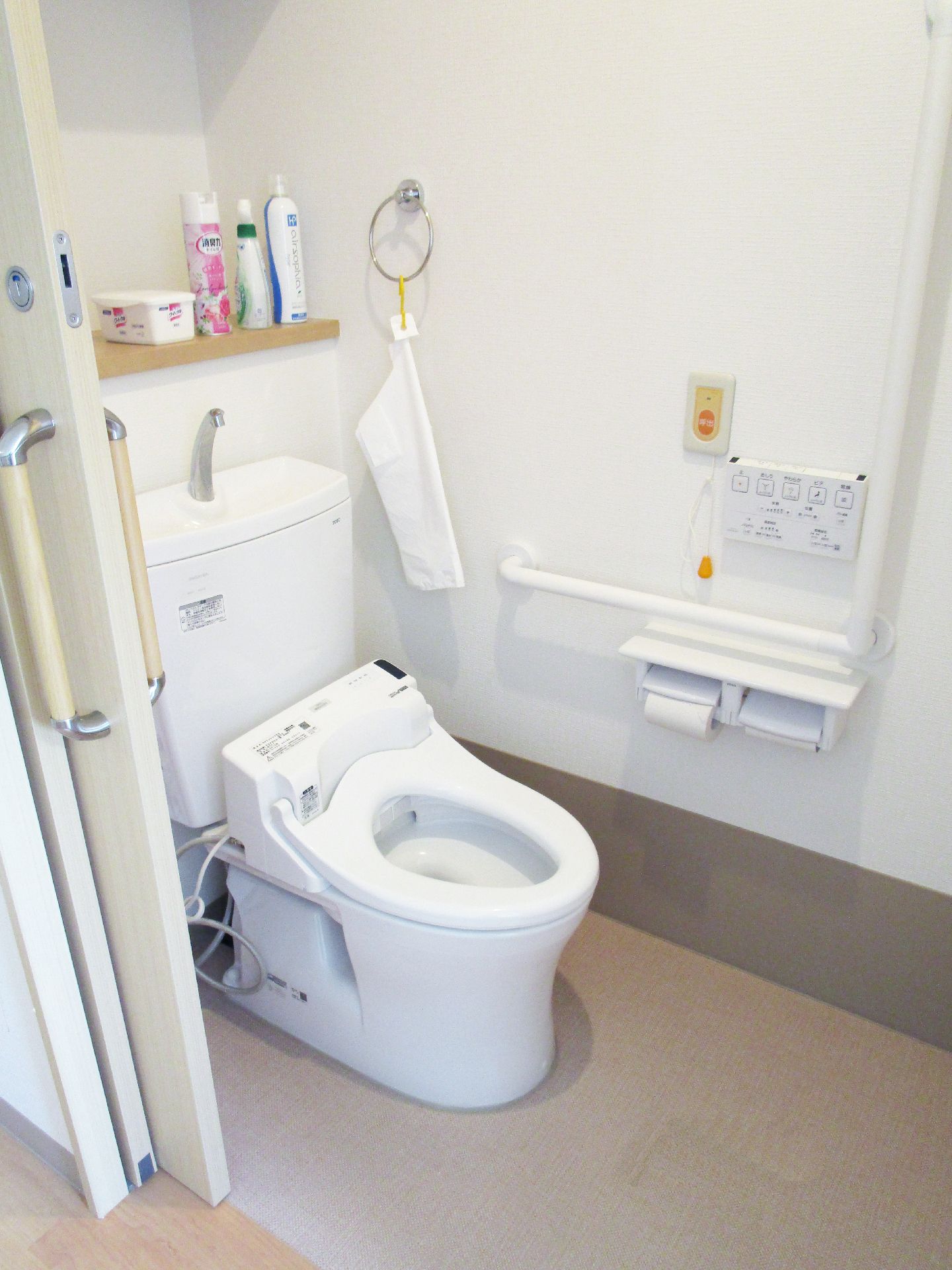 緊急コールと手すりが取り付けられている引き戸仕様の介護用トイレの様子