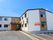 2階建ての建物。ブラウンと白で玄関には屋根が付き、外壁にはホーム名が書かれている。