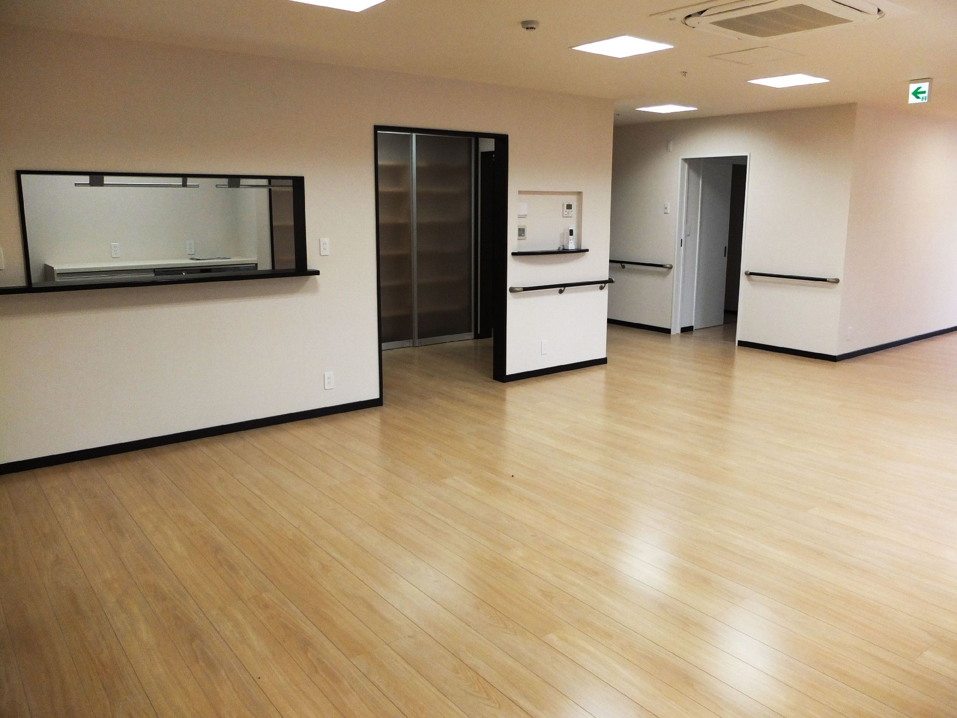 白い壁にはダークブラウンの手すりが付き、左手にはカウンターが付いた部屋がある。