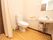 ゆったりとした清潔感あふれるトイレである。温水洗浄便座や洗面スペース、手すり、非常用呼び出しブザーが完備されている。