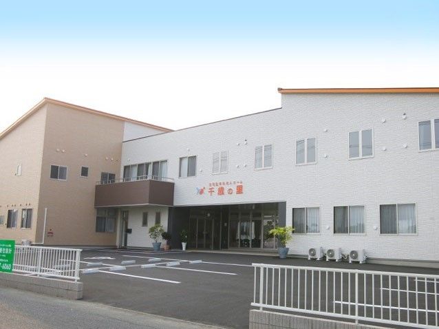 広い敷地内に大きな建物が建っている様子。複数台置ける駐車場スペースがある敷地