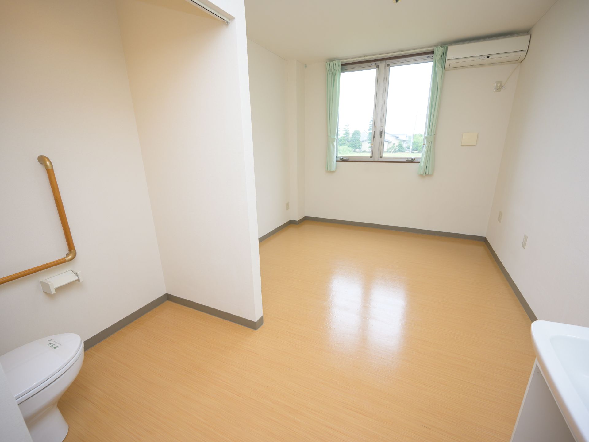 レールカーテンで仕切られた個室トイレが備わっている部屋