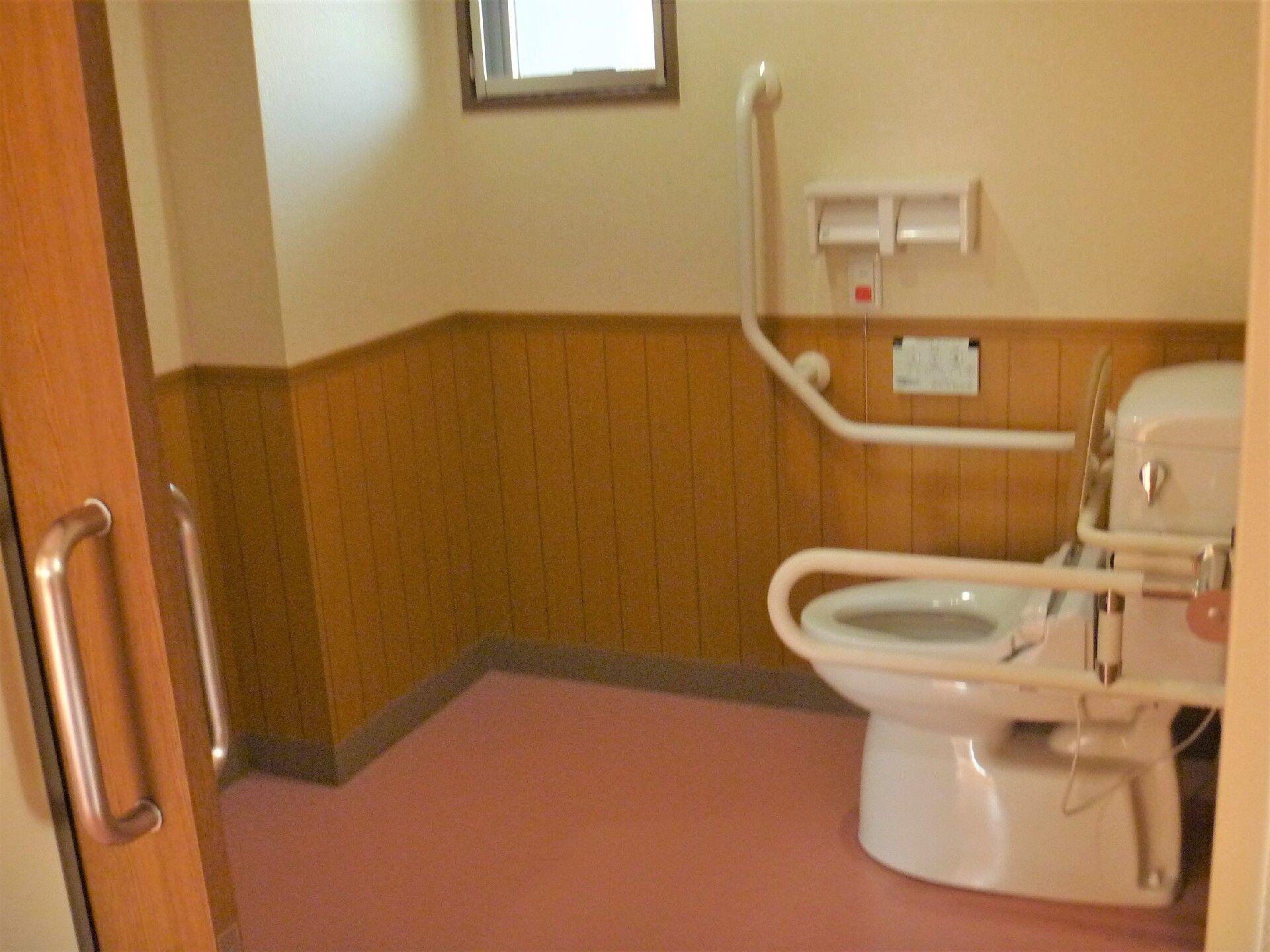 手すりと緊急コールが取り付けられている施設のトイレの様子