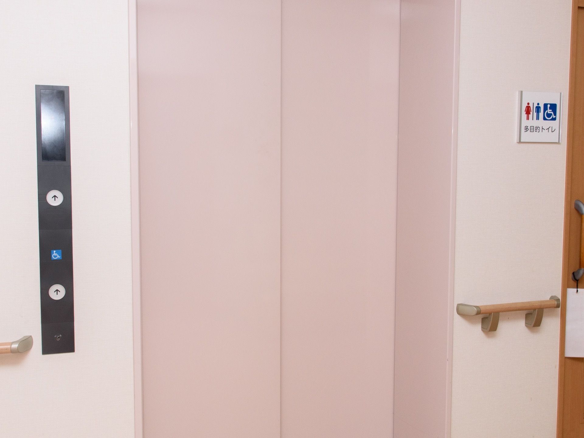 エレベーター乗降口のドアは、白い２段スライド式になっている。そのとなりには多目的トイレが設置されている。