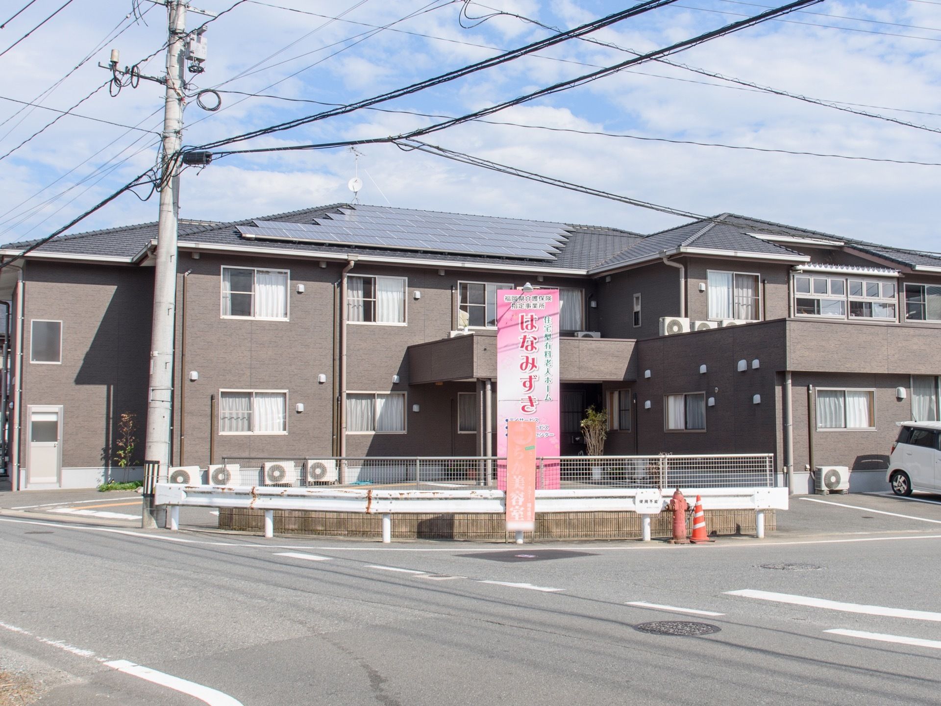施設は公道の交差点に面して建っている。建物本体はグレーの壁をした二階建て構造で、敷地は全面舗装されている。