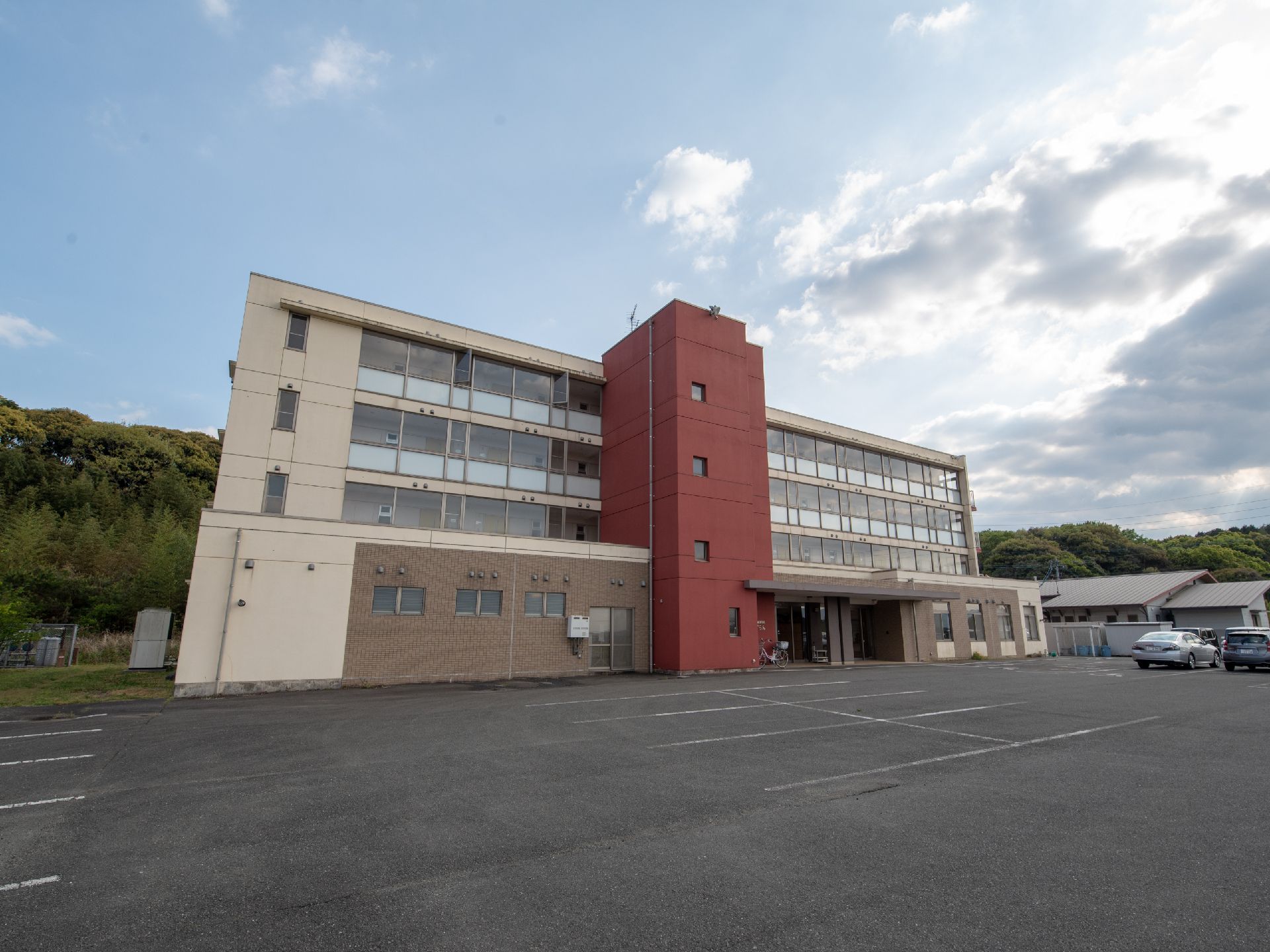 緑に囲まれた広い敷地内には平屋建ての建物と４階建ての建物がある。