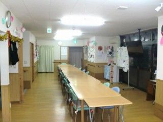 グリーンの椅子とベージュの机の組み合わせが複数ある広い空間