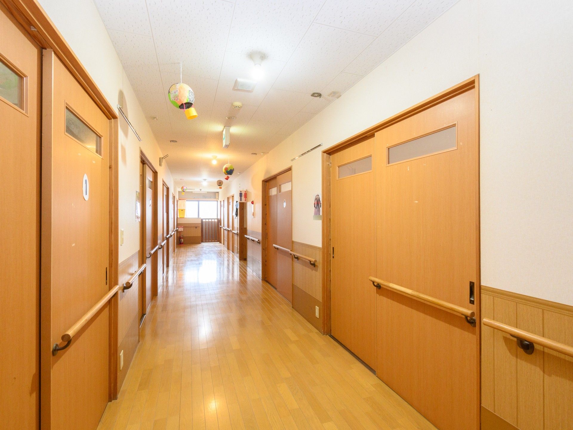 | 明るい廊下の居室入口  | 手すり沿いに整えられた廊下は、安全かつ快適な日々をサポートします。  | 廊下  | 清潔感漂う廊下の様子  | 手入れが行き届いた廊下で、お一人お一人のサポートに尽力しませんか。