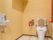 両サイドに手すりが設置されたトイレは広く、便座には背もたれも付いている。トイレ内に手洗い場もあり、棚も設置されている。