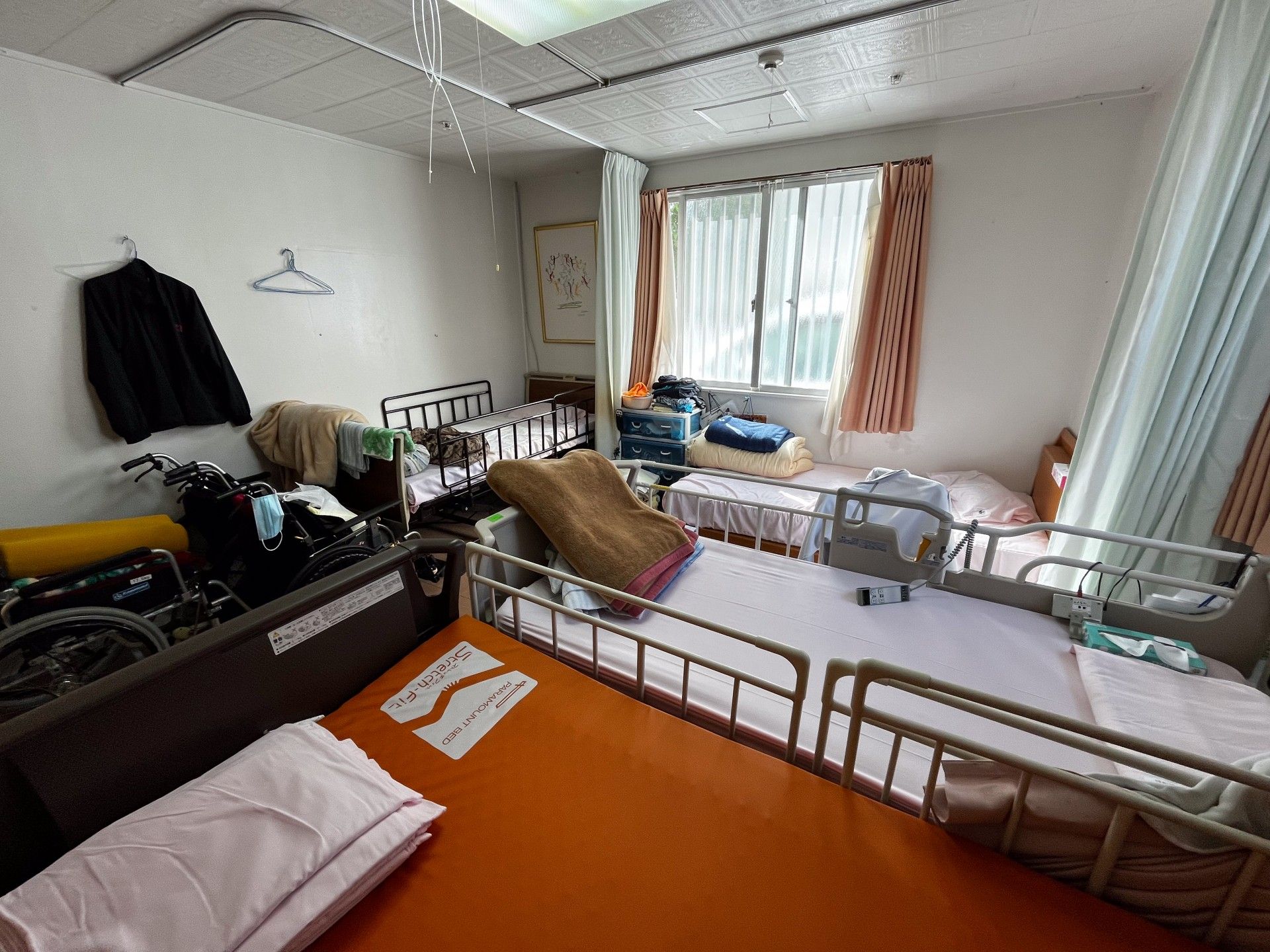 窓際のベッドと車椅子の部屋