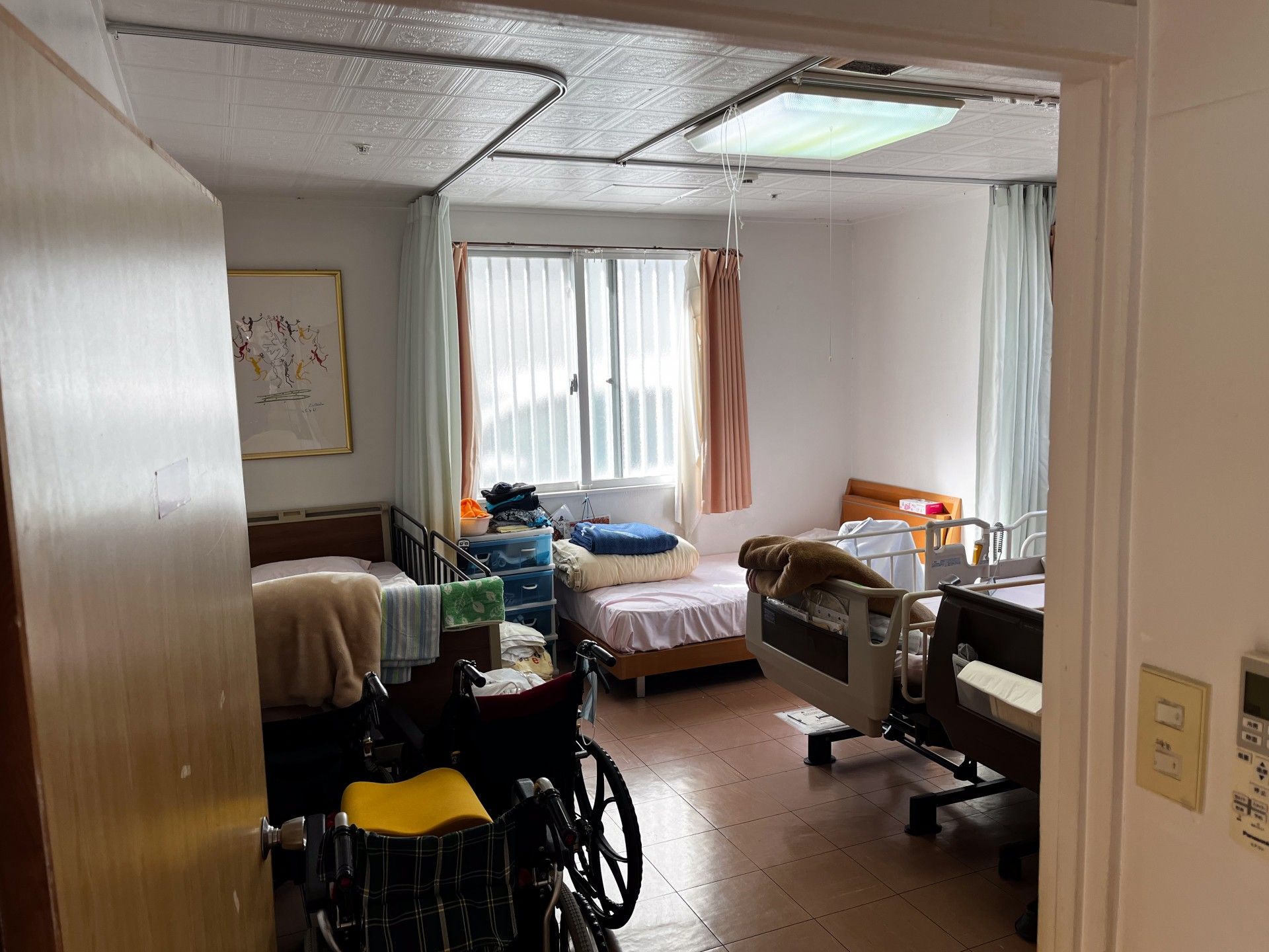窓際のベッドと車椅子の部屋
